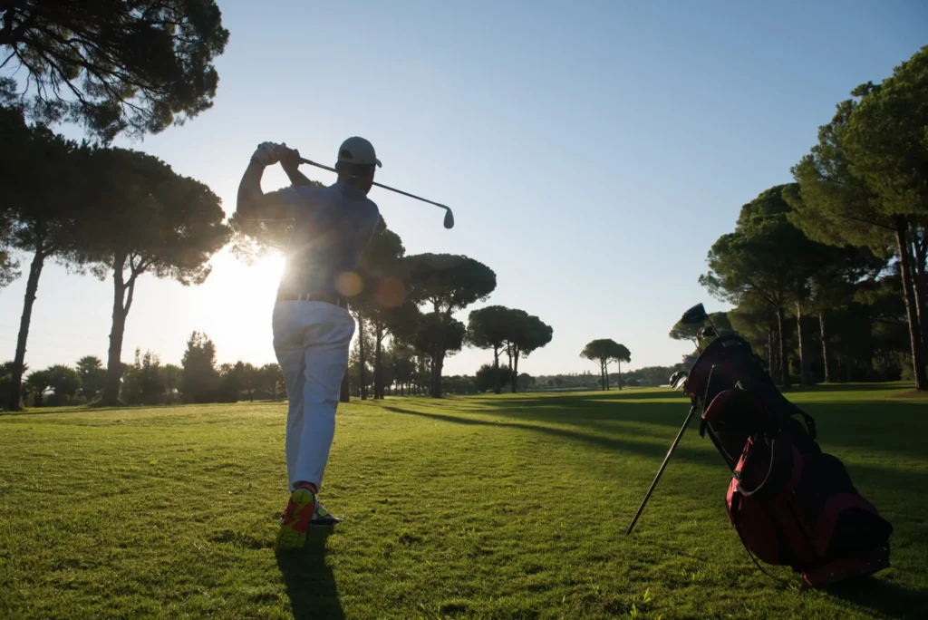 Golfer die net heeft afgeslagen op de fairway en aan het kijken is waar zijn bal naar toe gaat