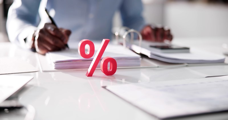 Een adviseur aan het werk in een dossier met voor hem een beeld van een percentage teken